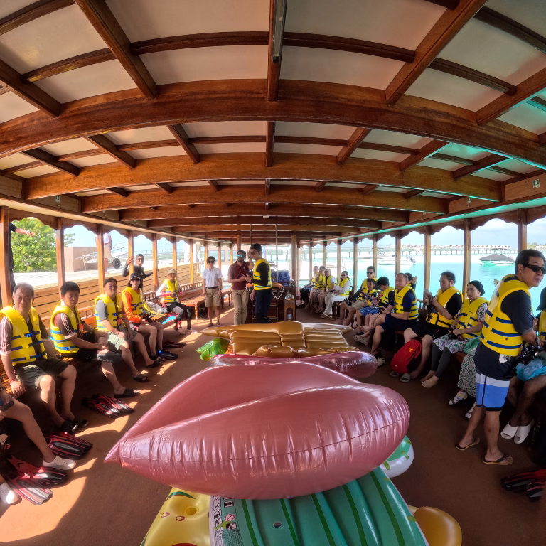 คณะเดินทางสวมเสื้อชูชีพเตรียมความพร้อมสำหรับกิจกรรมดำน้ำและเล่นน้ำ บนเรือไม้ท้องถิ่น (Dhoni) ในทริปมัลดีฟส์ พร้อมอุปกรณ์ห่วงยางแฟนซี